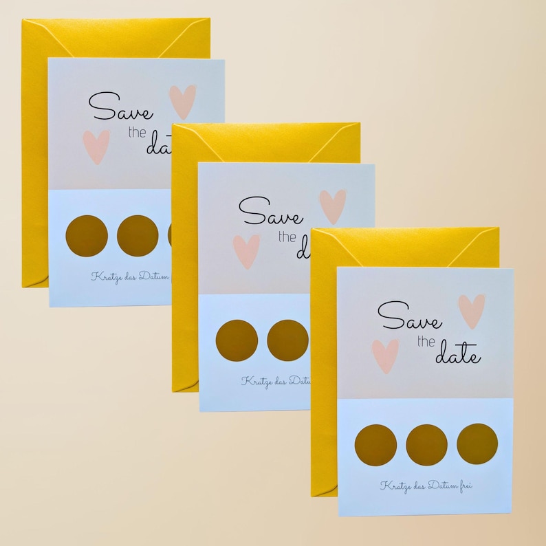May include: A collection of wedding announcement cards with yellow envelopes. Each card has the text "Save the date" with a heart graphic. The bottom section of each card has gold scratch-off circles.
