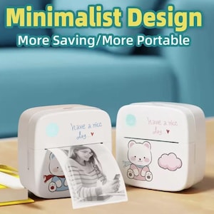 Op de afbeelding: Twee witte draagbare fotoprinters met een minimalistisch ontwerp. Elke printer heeft een schattige berengrafiek en de tekst "have a nice day". Eén printer print een zwart-witfoto. De afbeelding bevat ook de tekst "Minimalist Design" en "More Saving/More Portable."