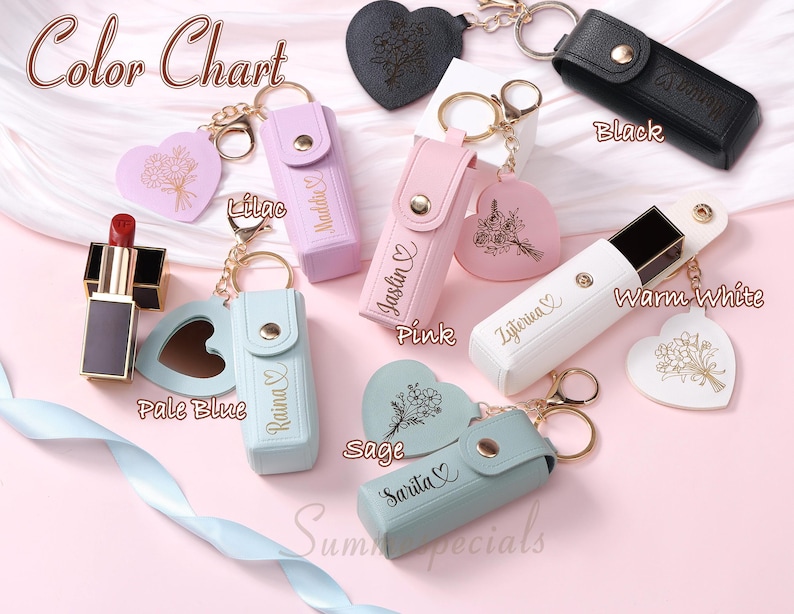 May include: A color chart featuring lipstick holders and heart-shaped keychains in various colors, including black, pink, lilac, and warm white. Each holder has a snap closure and a gold keychain. The text "Color Chart" is at the top.