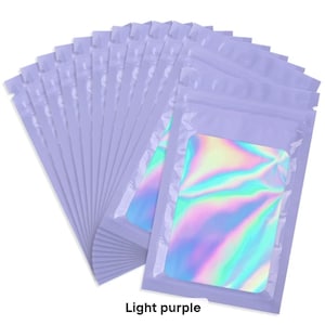 Puede incluir: Un conjunto de bolsas resellables de color lila claro, con una ventana transparente que muestra un inserto holográfico. El texto "Light purple" está impreso en la parte inferior. Estas bolsas son adecuadas para empaquetar artículos pequeños.