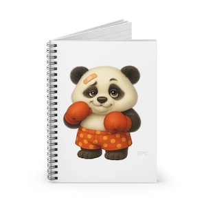 May include: Spiral-bound notebook featuring a cartoon panda bear wearing orange boxing gloves and shorts with orange polka dots. The panda has a bandage on its head and is smiling. The notebook has a white cover.