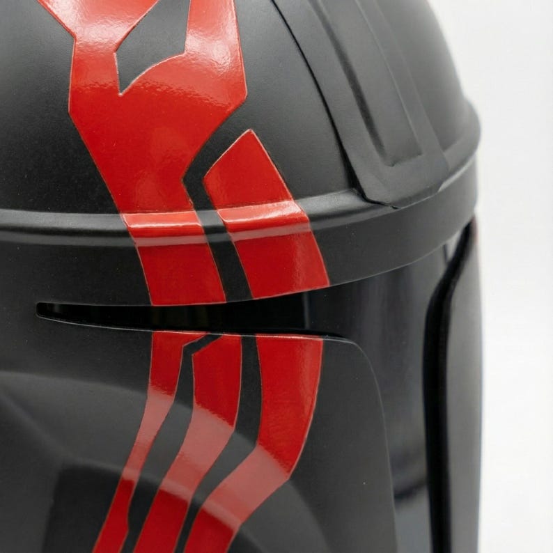 Hand-painted steel Mandalorian helmet in black with a bold red Mythosaur logo; cosplay armor style for fans.