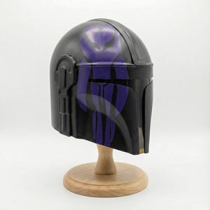 Hand-painted steel Mandalorian helmet in black with a bold red Mythosaur logo; cosplay armor style for fans.