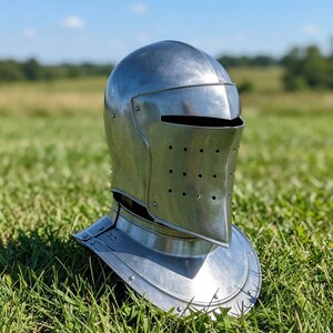 May include: A polished steel knight helmet featuring a rounded dome, a visor with a horizontal eye slit, and a lower face plate with a grid of small circular ventilation holes. The helmet includes a flared gorget piece at the base for neck protection.