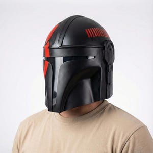 Hand-painted steel Mandalorian helmet in black with a bold red Mythosaur logo; cosplay armor style for fans.