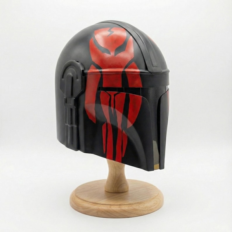 Hand-painted steel Mandalorian helmet in black with a bold red Mythosaur logo; cosplay armor style for fans.