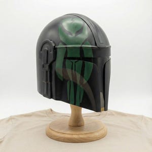 Hand-painted steel Mandalorian helmet in black with a bold red Mythosaur logo; cosplay armor style for fans.