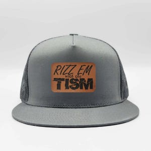 May include: Gray trucker hat with a mesh back and a curved brim. The hat features a brown leather patch with the words "RIZZ EM with the TISM" in a stylized font. The hat is a casual accessory.