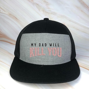 May include: Black and gray trucker hat with the embroidered text "MY DAD WILL KILL YOU" in pink. The hat features a mesh back and a curved brim. The front panel is gray.