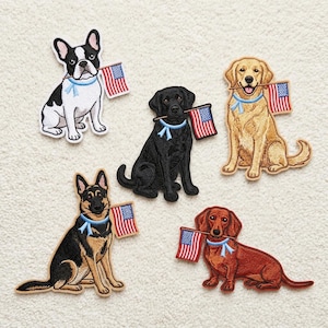 May include: Five embroidered dog patches, each holding a small American flag in their mouth. The dogs are a French Bulldog, Labrador, Golden Retriever, German Shepherd, and Dachshund. Each dog has a blue ribbon around its neck.