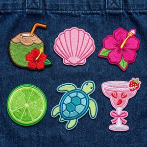 May include: Embroidered patches featuring tropical designs. Includes a coconut with a straw, a pink seashell, a pink hibiscus flower, a lime slice, a sea turtle, and a pink margarita glass with a strawberry.