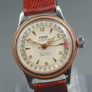 Może przedstawiać: Zestaw trzech ceramicznych kubków z nakrapianym, matowym wykończeniem. Kubki są w odcieniach kremu, jasnoszarym i ciemnoszarym. Każdy kubek ma prosty, minimalistyczny design i zaokrąglony uchwyt.