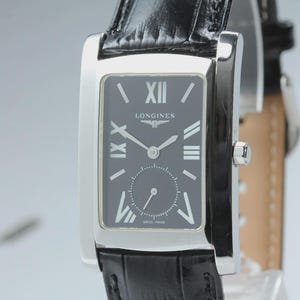 May include: A rectangular silver-tone wristwatch with a black dial featuring white Roman numeral hour markers, silver hands, and the Longines logo. The watch includes a small sub-dial for seconds and is attached to a black textured leather strap.