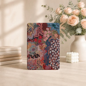 May include: A rectangular tablet case featuring a vibrant, abstract pattern with intricate red, blue, pink, and gold details. The design includes swirling shapes, circular motifs, and textured lines across the entire surface of the protective cover.