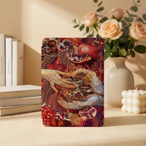 May include: A rectangular art print featuring a detailed illustration of pomegranates and hands. The artwork showcases a rich color palette of reds, browns, and golds, with a focus on the fruit's textures and the interaction between hands.