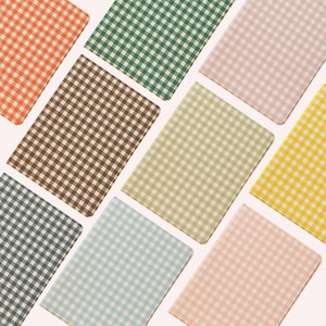 May include: A selection of notebooks featuring a gingham design in a range of colours: orange, green, brown, pink, yellow, blue, and beige. The notebooks are arranged at angles, displaying the variety of colours available.