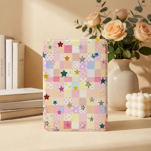 May include: A rectangular case with a patchwork design of pastel squares and colorful star accents. The case features a variety of colors, including pink, yellow, blue, and green. The stars are in various sizes and textures, adding a playful touch.