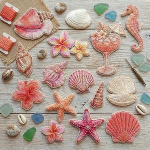 May include: Embroidered seashell and tropical flower designs in shades of pink, orange, and white. The collection includes starfish, a seahorse, and a cocktail with a tiny umbrella. The items are arranged on a light wood surface.
