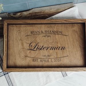 May include: A wooden serving tray with brass handles. The tray is engraved with the text "Ryan & Shannon Listerman Est. April 2, 2022".