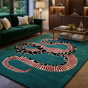 Puede incluir: Alfombra turquesa con un gran diseño de serpiente. La serpiente presenta un patrón en blanco y negro en su cuerpo y rayas rojas y blancas a los lados. La alfombra está en un salón con un sofá verde y suelos de madera.