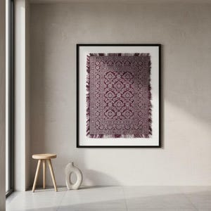Peut inclure: Impression d'un tapis rectangulaire encadré, orné d'un motif floral détaillé dans des tons bordeaux et crème. Le tapis a une bordure à franges et est encadré de noir. Un petit tabouret en bois et un vase en céramique blanc sont au premier plan.