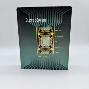 May include: A hardcover book titled "Electric Circuits" with a teal and black cover. The cover features a circuit board design with gold and teal accents. The author's name, David A. Bell, is printed at the bottom.