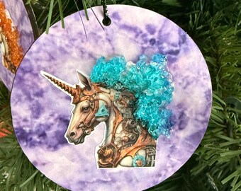 Adorno navideño de unicornio. Melena de cristal azul con fondo morado.