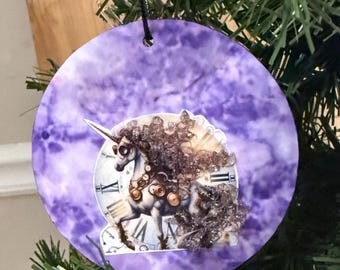 Adorno navideño de unicornio. Copa de champán con crin y cola sobre fondo morado.