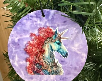 Adorno navideño de unicornio. Melena de cristal rosa con fondo morado.