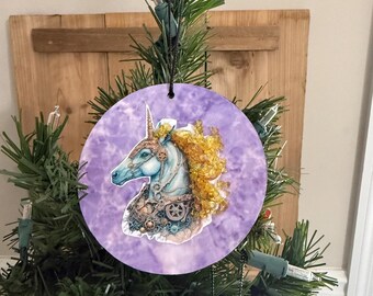 Adorno navideño de unicornio. Melena de cristal amarilla y fondo morado.