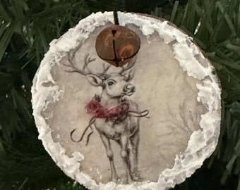 Reno con bufanda roja. Adorno navideño rústico de madera con campana oxidada y bordes esmerilados.