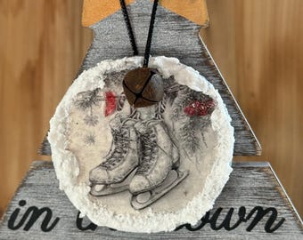 Patines de hielo. Adorno navideño rústico de madera con campana oxidada y bordes esmerilados.