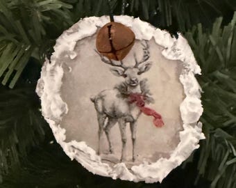 Adorno navideño rústico de madera con forma de reno, campana oxidada y bordes esmerilados.