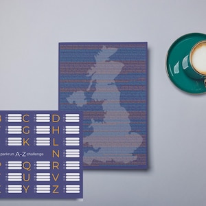 Op de afbeelding: Een platte lay-out met een teal kop en schotel met een gouden oor, naast twee rechthoekige prints. Eén print toont de omtrek van het VK, de andere het alfabet met de tekst "parkrun A-Z challenge".