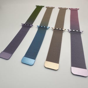 May include: Six magnetic mesh watch bands in various colors: purple, olive green, blue, tan, gold, and pink. Each band has a matching colored clasp and end piece. The bands are designed to fit a smartwatch.