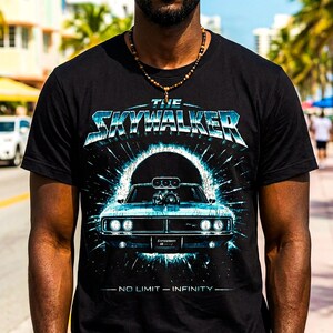 Puede incluir: Camiseta negra con un gráfico estilizado de un coche deportivo clásico y el texto "THE SKYWALKER" en azul y blanco. El diseño incluye el texto "NO LIMIT - INFINITY" debajo del coche.