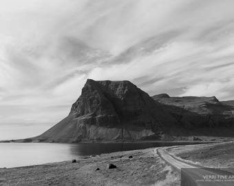 Könnte beinhalten: Schwarz-Weiß-Landschaftsfotografie eines Berges an einem Gewässer. Eine Straße führt zum Berg, mit einem bewölkten Himmel. Das Bild ist ein Kunstdruck.