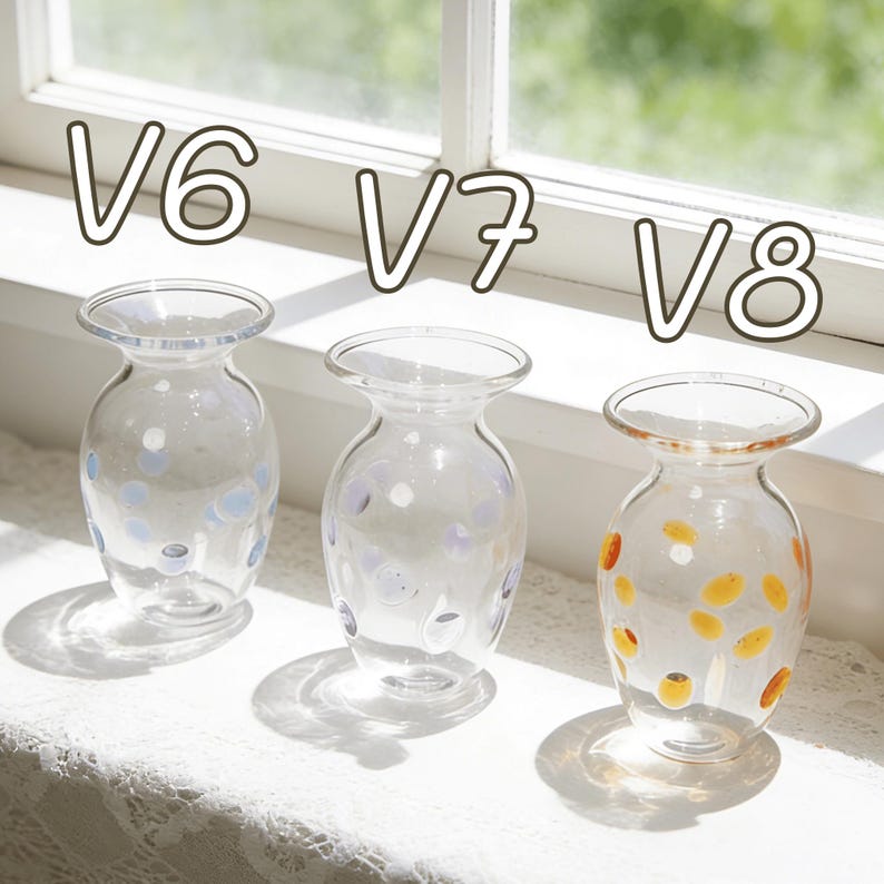May include: Three clear glass vases with rounded bodies and flared rims are displayed on a white surface. The vases are decorated with colorful polka dots. The text "V6", "V7", and "V8" is above each vase.