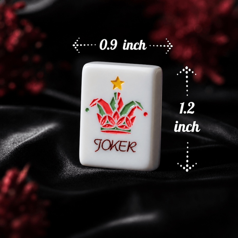 May include: A white rectangular mahjong tile featuring a colorful joker hat graphic with a yellow star above it and the word JOKER printed in red below. The tile measures 0.9 inches in width and 1.2 inches in height as indicated by arrows.