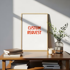 Puede incluir: Un marco con las palabras "CUSTOM REQUEST" en naranja. La impresión se muestra sobre una mesa de madera con libros, una vela y un jarrón con vegetación. El marco es dorado.