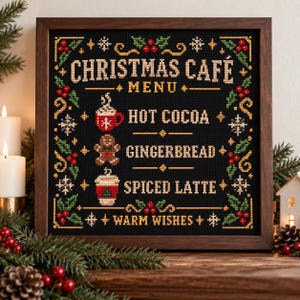 Op de afbeelding: Een ingelijste kruissteek op zwarte stof met de tekst CHRISTMAS CAFE MENU, HOT COCOA, GINGERBREAD, SPICED LATTE en WARM WISHES. Het ontwerp bevat iconen van een mok, een peperkoekmannetje en een beker, omlijst door hulst en sneeuwvlokken.