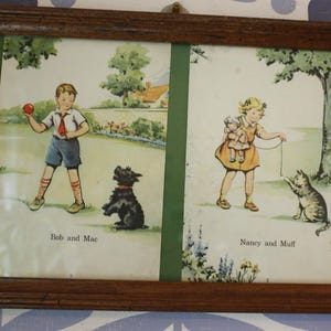 May include: Framed vintage print featuring two panels. The left panel shows a boy with a red ball and a black dog. The right panel depicts a girl with dolls and a cat. Text reads "Bob and Mac" and "Nancy and Muff".