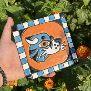 May include: A set of three ceramic mugs with a speckled, cream-colored glaze. Each mug features a different hand-painted floral design in shades of blue, green, and yellow. The mugs have a simple, rounded shape and a comfortable handle.