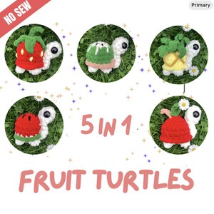 May include: Five crocheted fruit turtles are displayed on a green grassy background. Each turtle has a white body and head with large black eyes. The turtle shells are designed to look like a strawberry, watermelon, pineapple, apple, and a green melon. The text "5 IN 1" and "FRUIT TURTLES" are also visible.