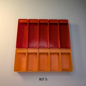 May include: A collection of rectangular plastic containers in shades of red and orange. The containers are arranged in two rows, with the top row in a darker red and the bottom row in a lighter orange. The text "KIT 5" is visible.