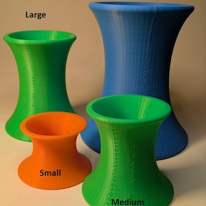 May include: Four 3D-printed hourglass-shaped vases in various sizes and colors. The vases are labeled "Small" (orange), "Medium" (green), "Large" (green), and "Extra Large" (blue). The text "SECOND CITY STANDARD.COM" and "CHUCK LARGE" are printed on the vases.