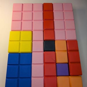 May include: A colorful puzzle game with a grid of square blocks in various colors. The blocks are arranged in rows and columns, with colors including pink, red, yellow, blue, orange, purple, and black. The game is designed for visual and spatial reasoning.