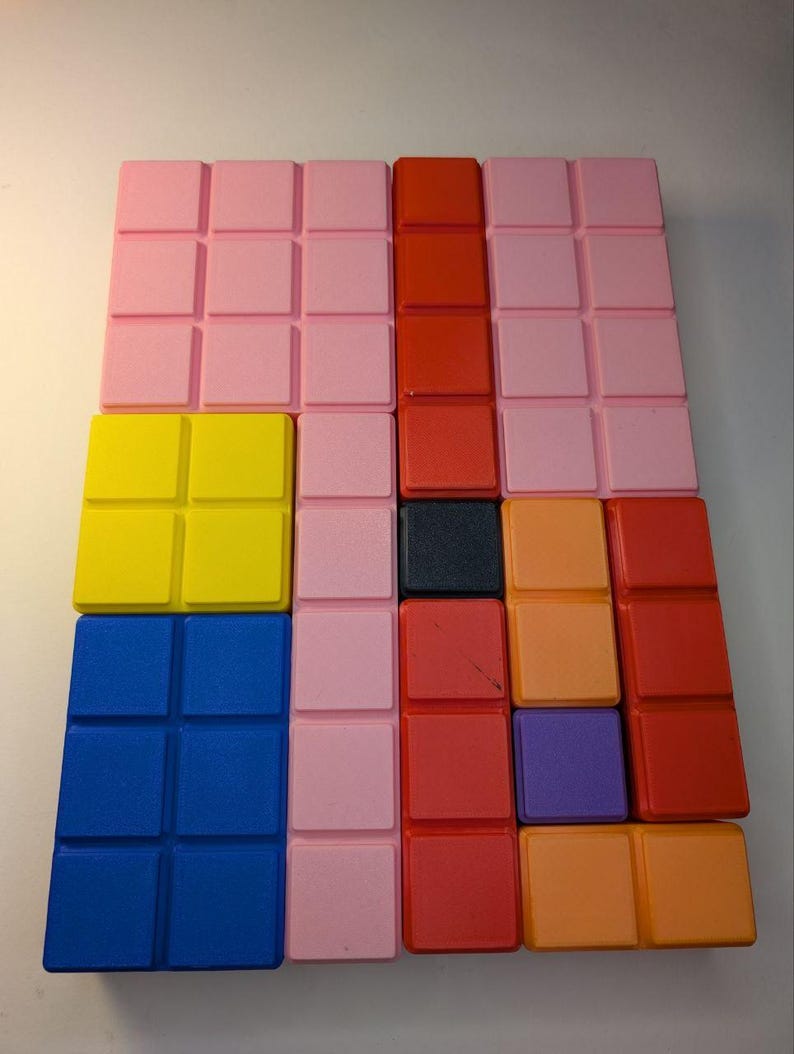 May include: A colorful puzzle game with a grid of square blocks in various colors. The blocks are arranged in rows and columns, with colors including pink, red, yellow, blue, orange, purple, and black. The game is designed for visual and spatial reasoning.
