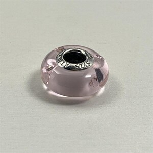 May include: A white ceramic mug with a black handle and the text "But First, Coffee" in a black, handwritten-style font. The mug is on a white surface.