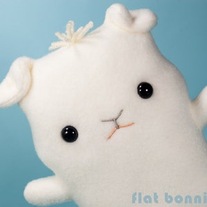 May include: White plush toy shaped like a bunny with black eyes and a stitched nose. The toy has a fluffy white tail and is made of soft fabric.